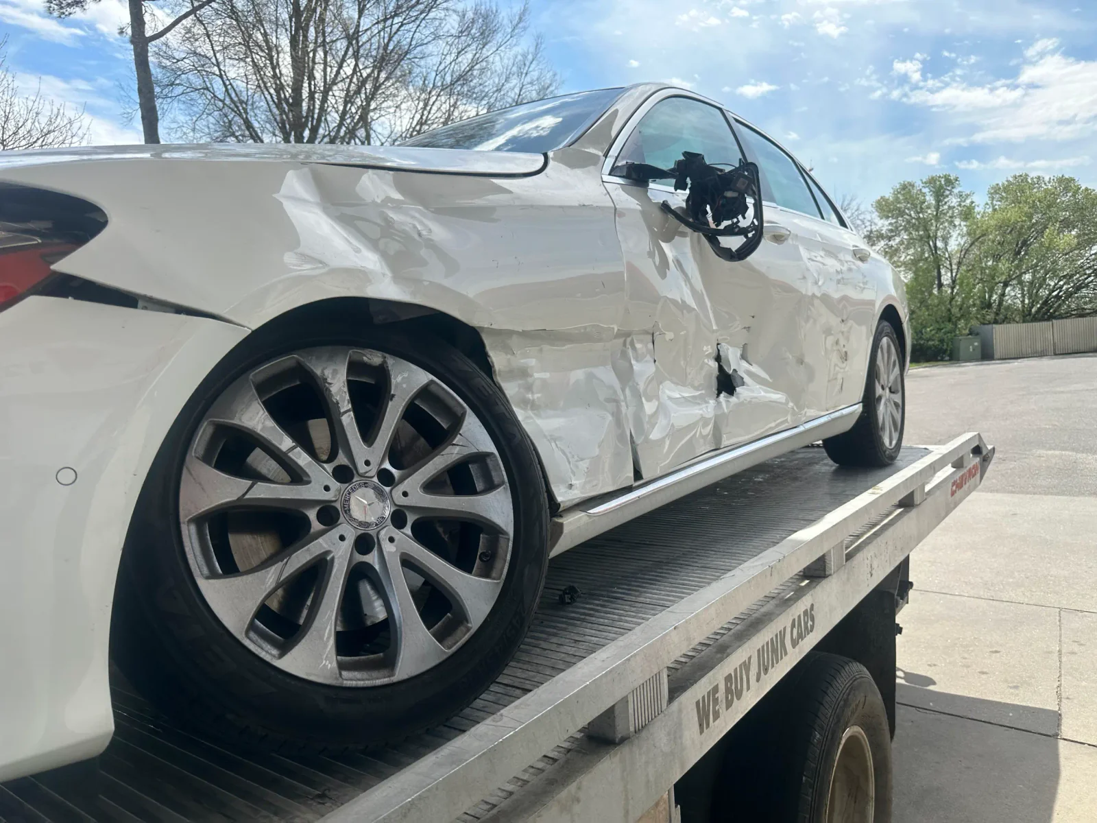 Damaged white sedan on a flatbed